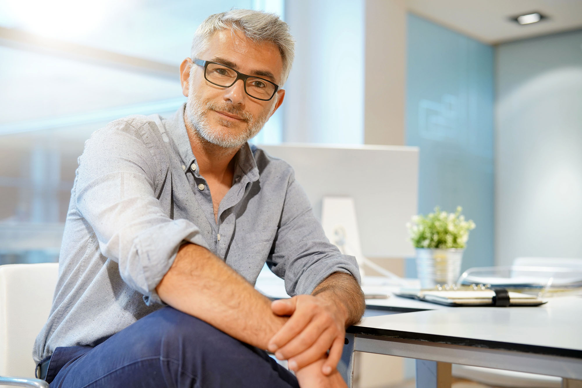 Portrait of smart casual businessman looking at camera in contemporary office